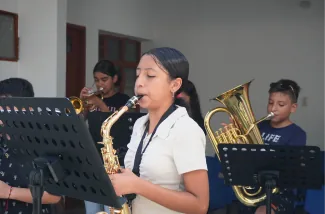 Joven tocando saxofón en una banda